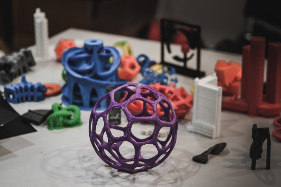 models-printed-by-3d-printer-dark-copy-space-bright-colorful-objects-printed-3d-printer-table-modern-additive-technologies-4-0-industrial-revolution-large
